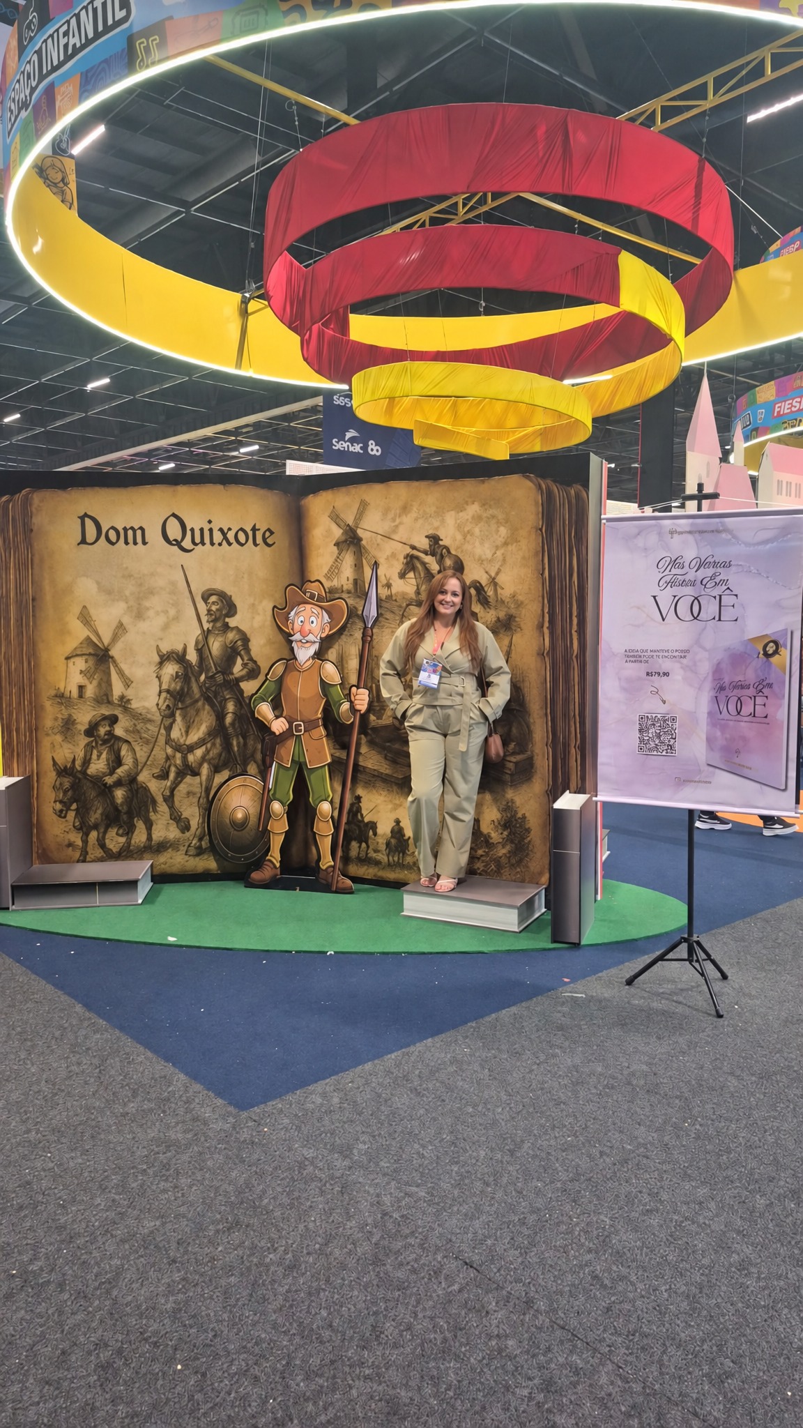 Três autoras ao lado do banner e cenário Dom Quixote