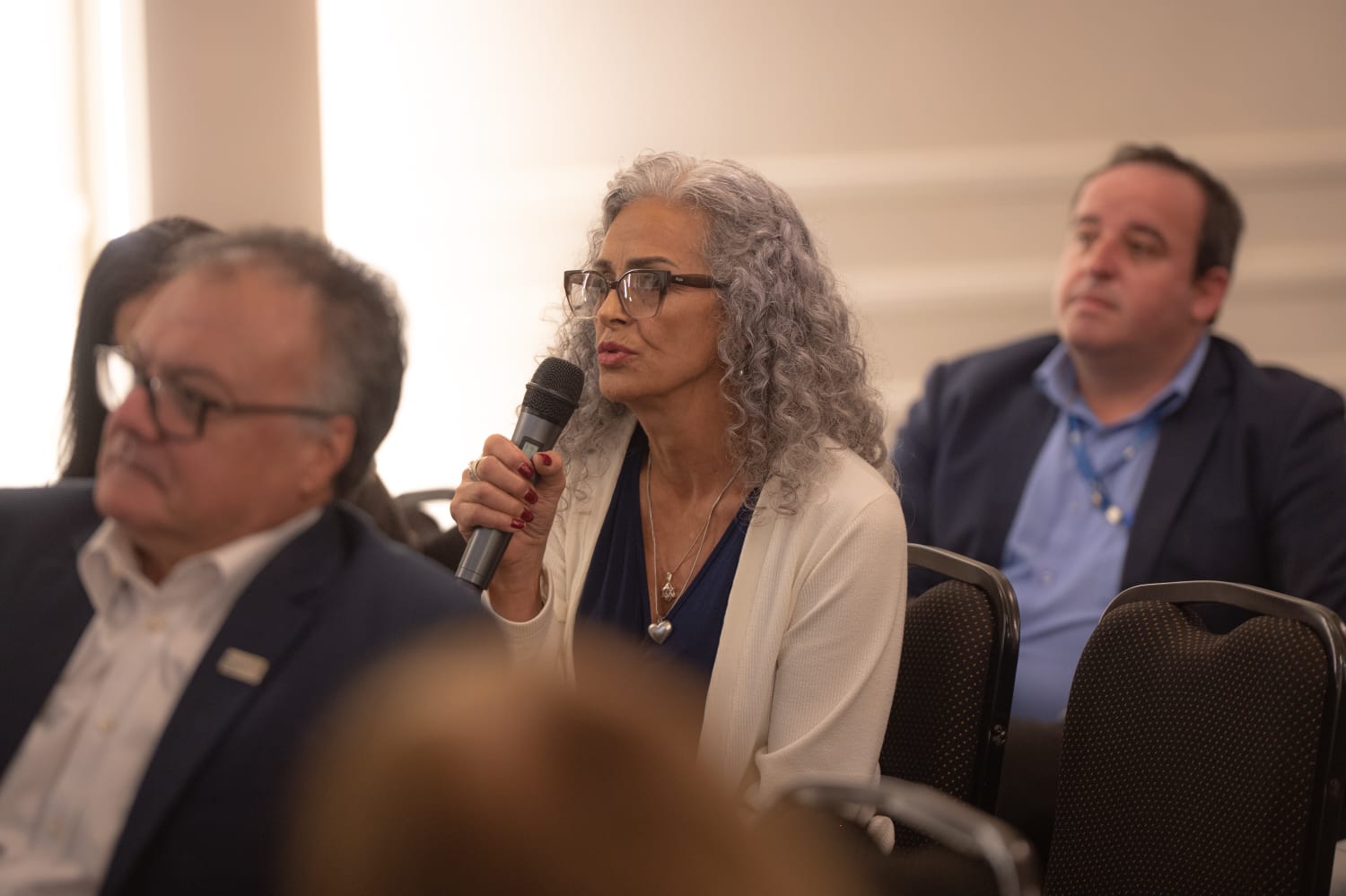Kátia Coimbra, representante do IFA em MG, faz intervenção com microfone no Seminário PLP 108/2021 em Belo Horizonte